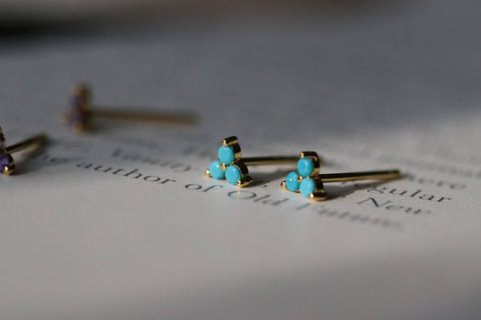 Shan&Co's Gold Vermeil CZ Turquiose Shamrock Stud Earrings featuring a crystal turquiose in a shamrock design, paired with Turquiose Three Dot Earrings and Dainty Gold Trinity Leaf Earrings, blending elegance with nature-inspired charm in high-quality gold vermeil.