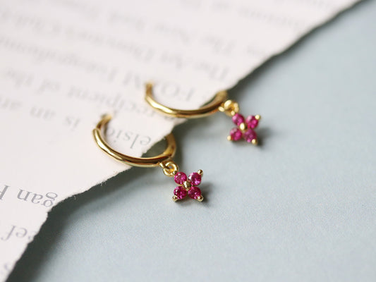 Shan&Co's Gold Vermeil Four Leaf Clover Pink CZ Dangle Huggies Earrings, featuring a delicate four-leaf clover charm adorned with pink crystal zirconia, perfect for adding a touch of elegance and luck to any outfit.